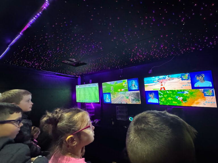 Young kids watching the big screens inside the video game truck