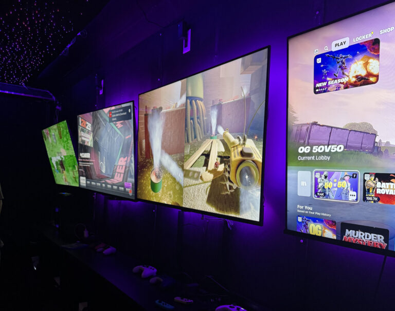 Row of large gaming screens inside the Gamers Getaway video game truck