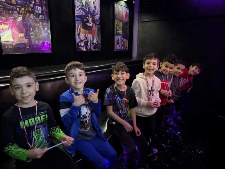 Kids giving a thumbs up on the bench inside the Gamers Getaway video game truck