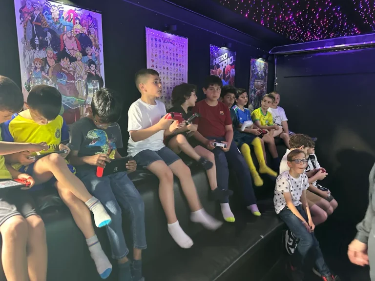 Kids holding controllers and playing together inside the game truck